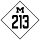 A road sign bearing a diamond enclosing a block M and the number 213