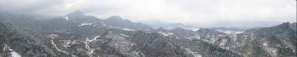 Forested hills covered with snow, seen from an elevated position on Maijishan